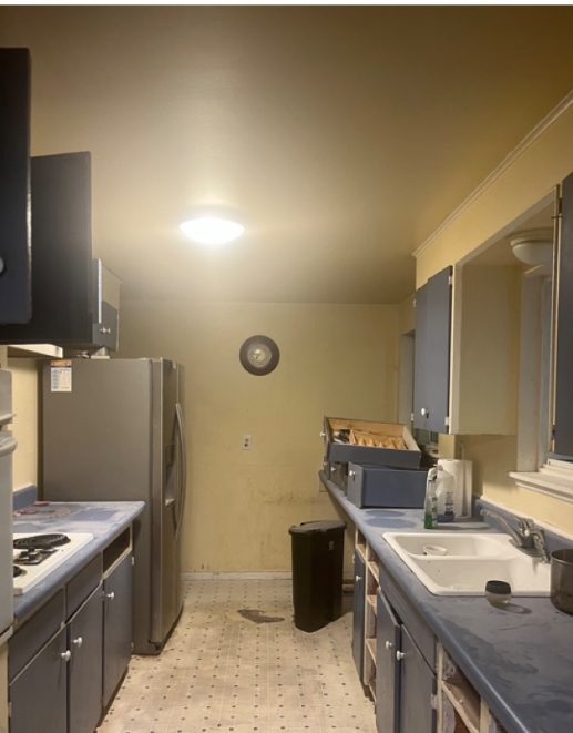Kitchen before remodel, dated cabinets and worn flooring