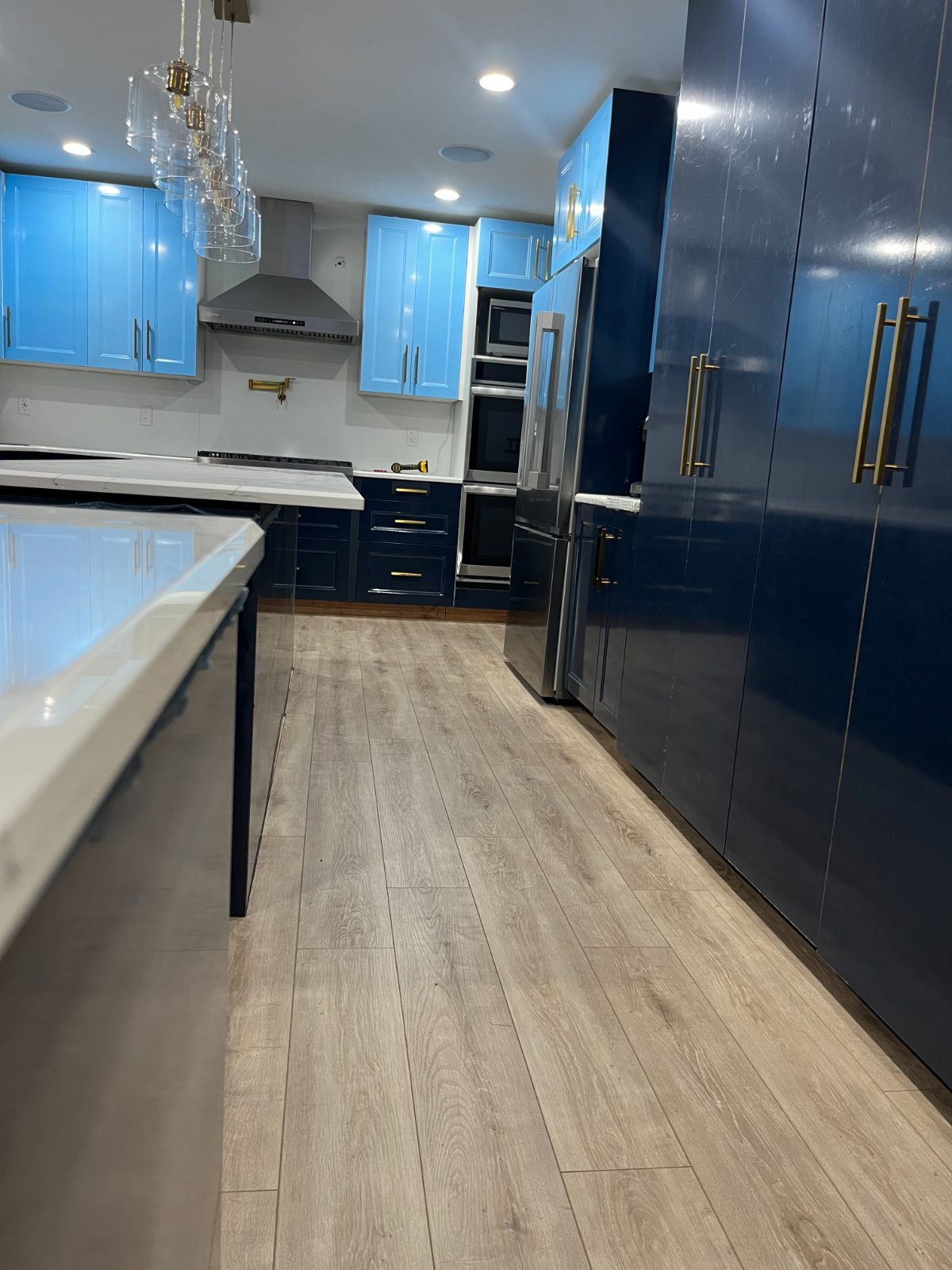 Navy gloss kitchen seen from the hallway