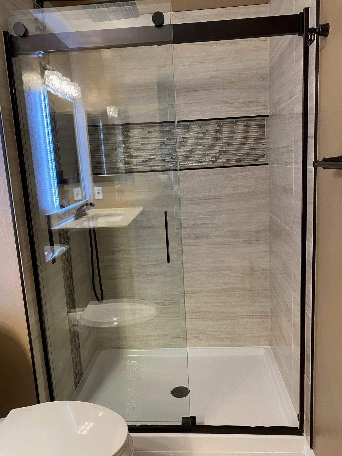 Tile shower with frameless glass and matte black fixtures